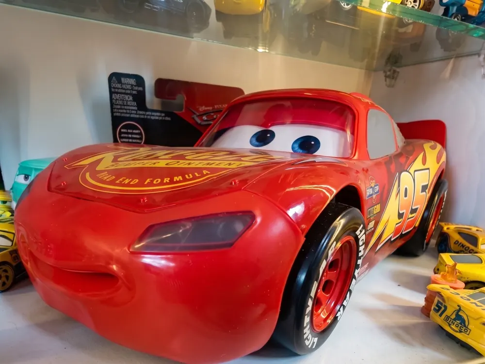 Rayo McQueen de gran tamaño ocupando la repisa superior de la sala